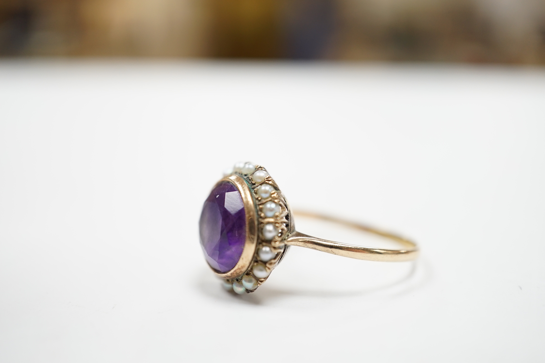 A mid 20th century 14k yellow metal, amethyst and seed pearl set circular cluster ring, size U/V, gross weight 4.3 grams.